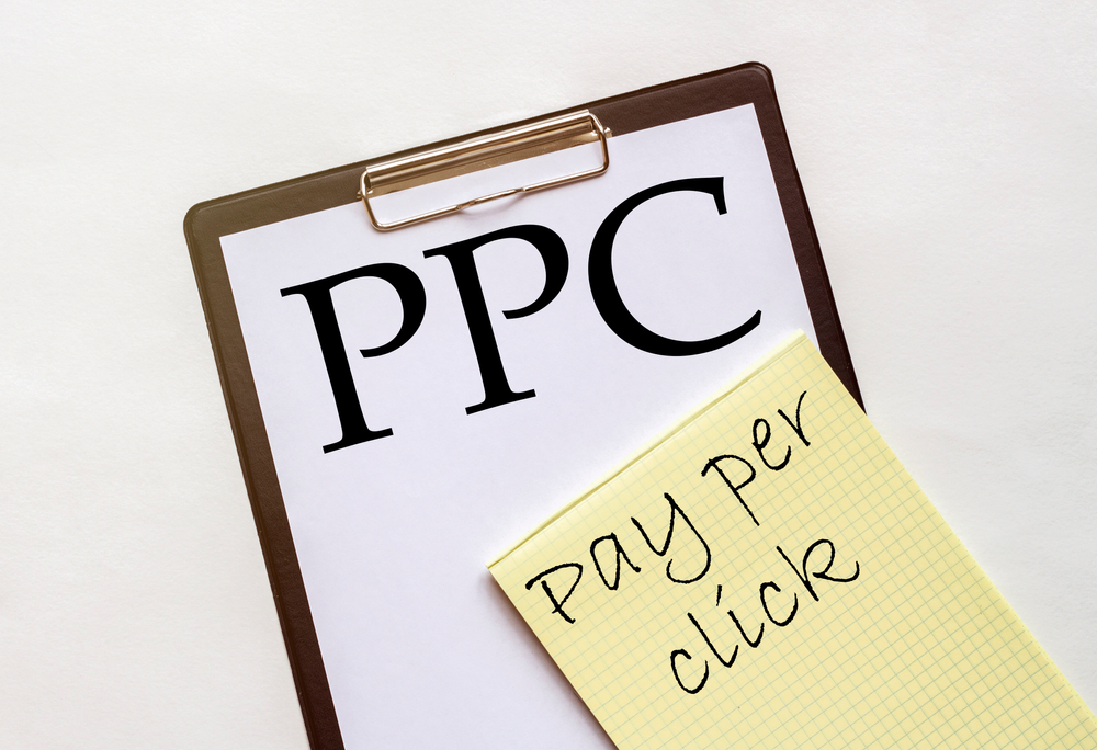 Pay per click written on yellow sticky note and clipboard