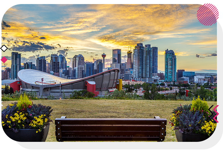 View of downtown Calgary buildings from behind a bench up on a hill